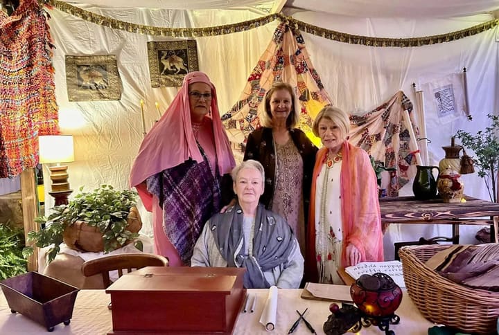 Volunteers in period dress inside a decorated marketplace tent.