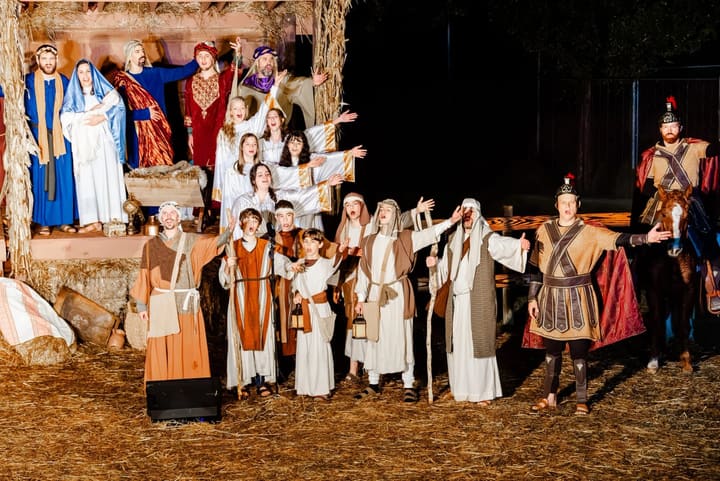 The volunteer cast of the nativity in costume, with a Roman soldier on horseback.